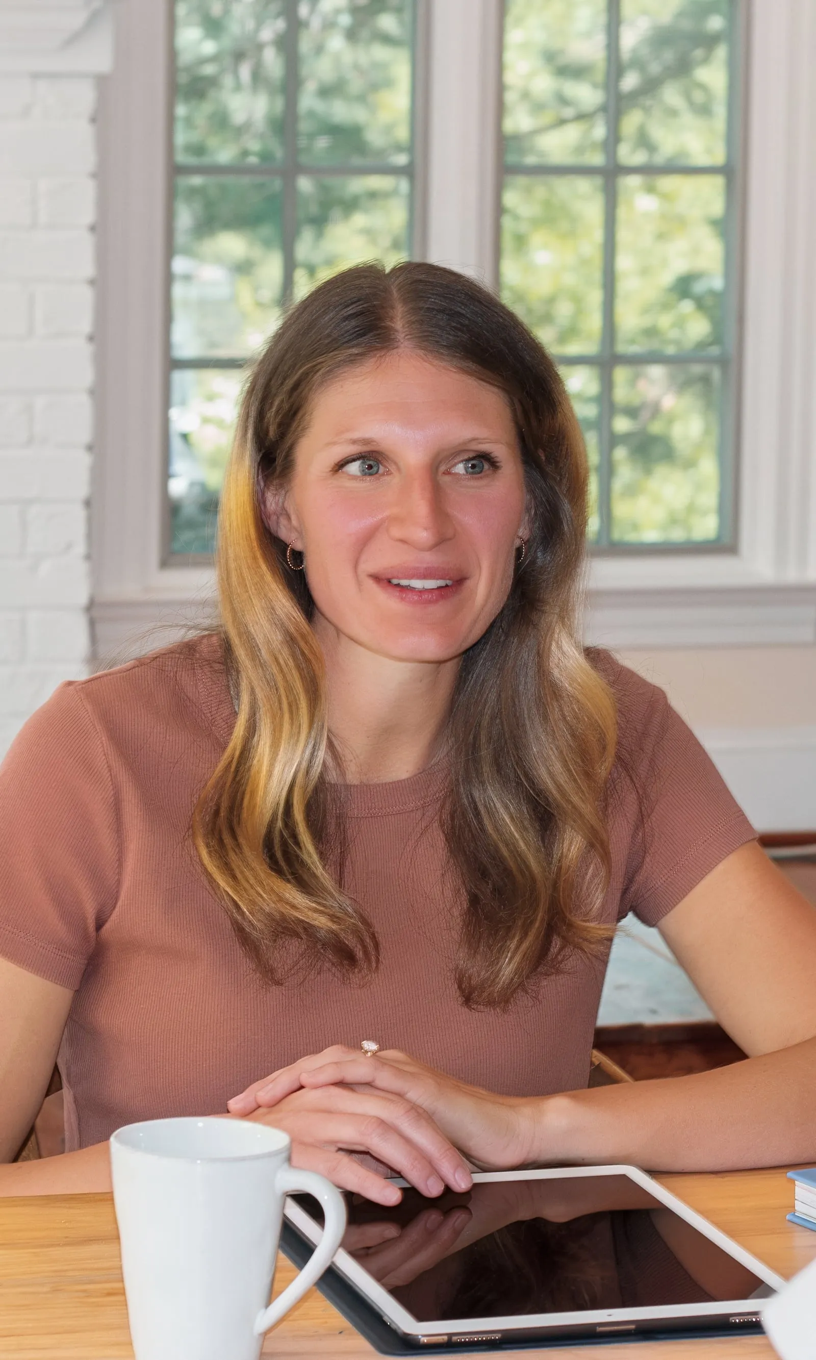 Kelsey Shaughnessy, RDN, talking with a client at a table in a sunny living room
