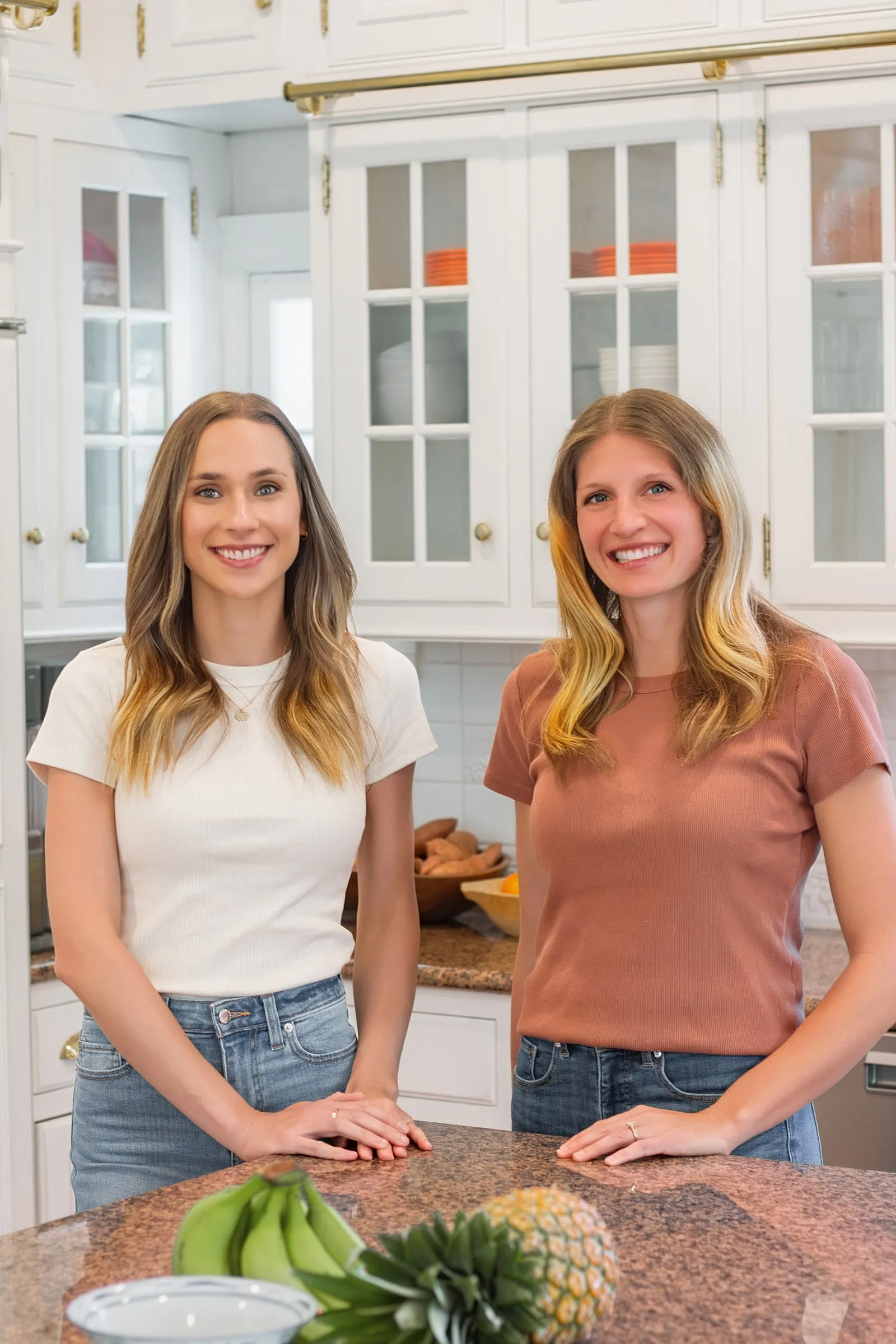 Registered dietitians Macie Fuquay and Kelsey Shaughnessy of Finesse Nutrition, smiling together at a kitchen island